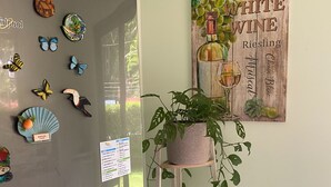 A kitchen with a refrigerator, decorative magnets, a potted plant, and a wall-mounted sign. - Tranquil Beachside Retreat with Private Pool in Garabito (Garabito)