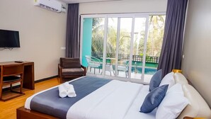 A hotel room with a large bed, a TV, a desk, and a balcony with a view of the sea. - Psygroover Rococco (Mandrem)