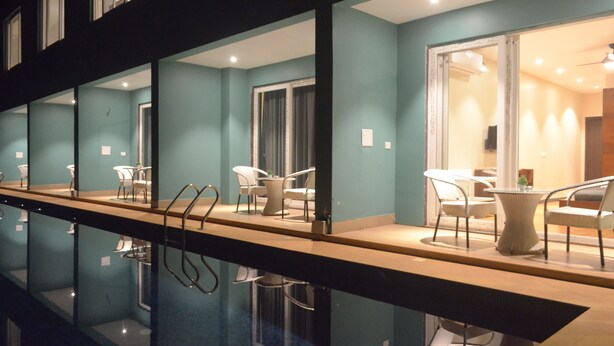 A poolside area with a long bench, chairs, and a table with chairs. - Psygroover Rococco (Mandrem)