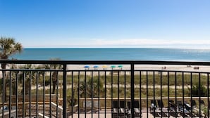 Ein Balkon mit Blick auf Strand und Meer.