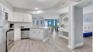 A modern kitchen with white cabinets, stainless steel appliances, and a central island.