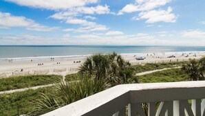 Een strand met een heldere lucht, palmbomen en een zandrijk strand.