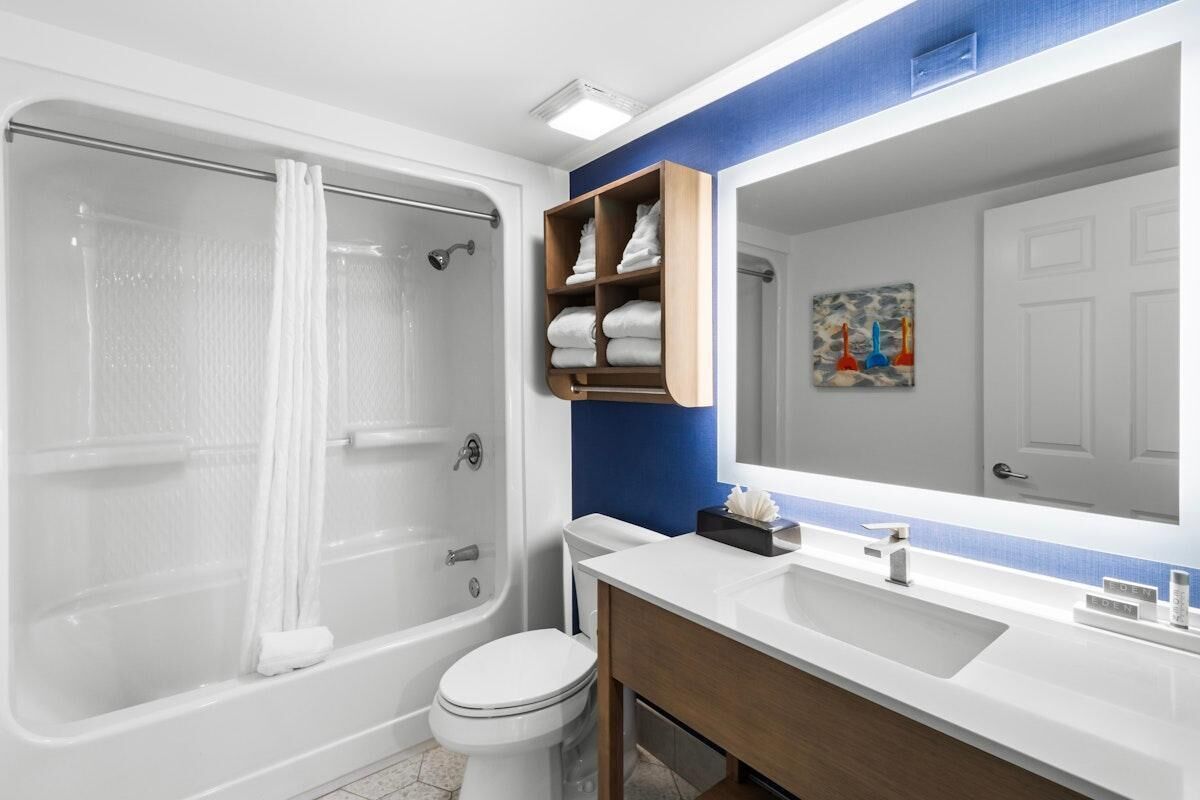 Ein modernes Badezimmer mit Badewanne, Toilette und einem Waschtisch mit Spiegel.