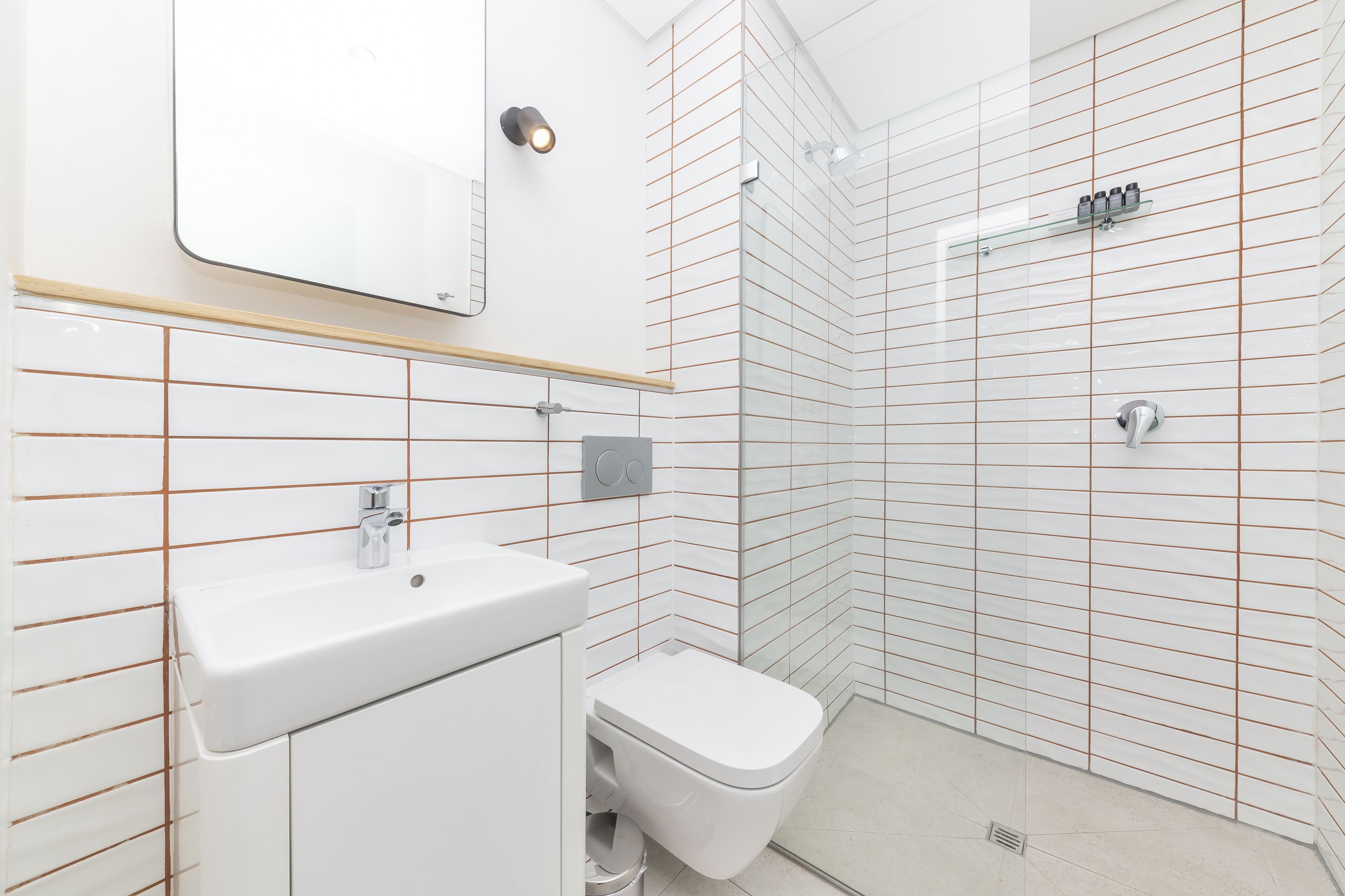 Ein modernes Badezimmer mit Waschbecken, Toilette und Duschkabine aus Glas.