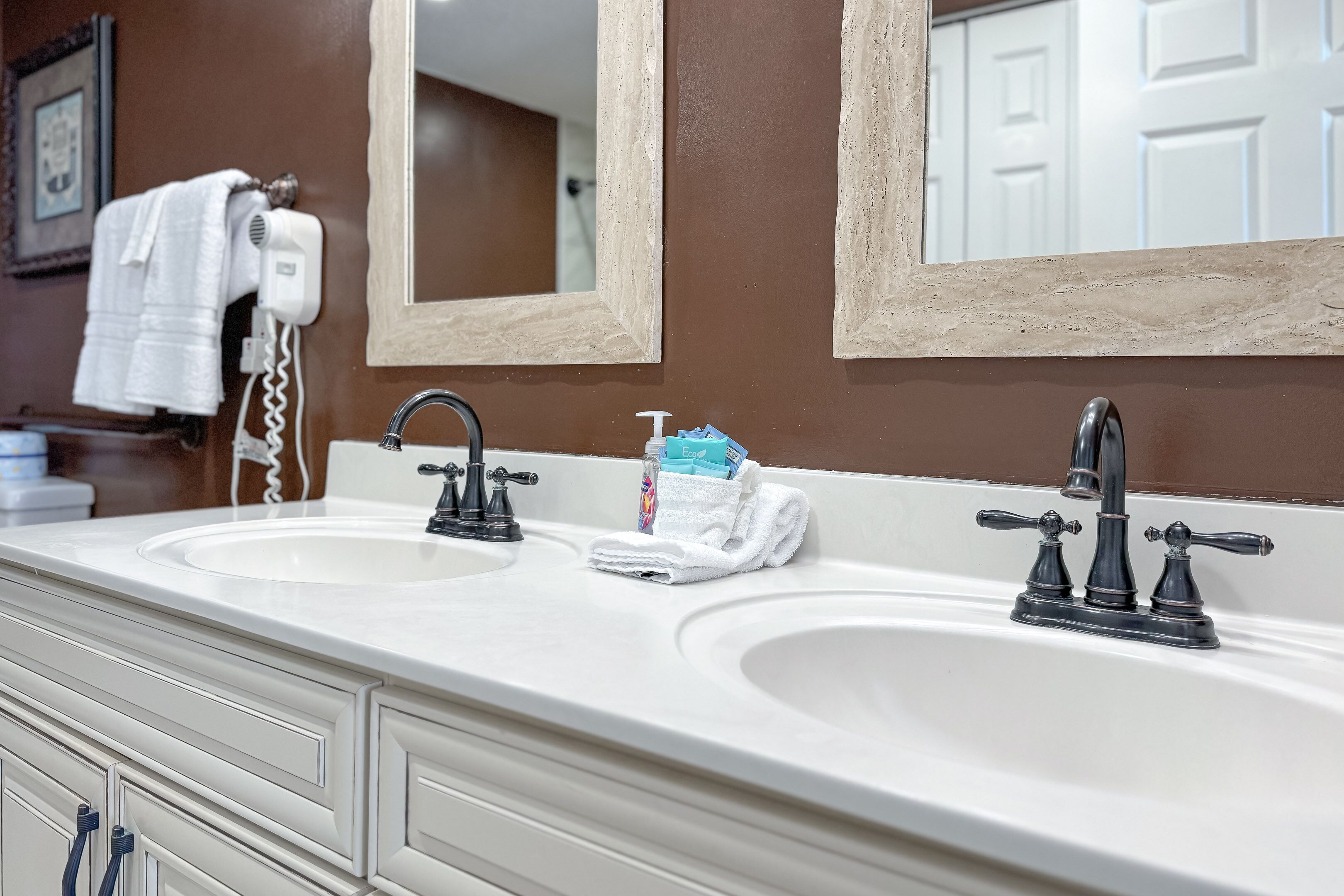 Une salle de bain avec deux lavabos, un miroir et un porte-serviettes.