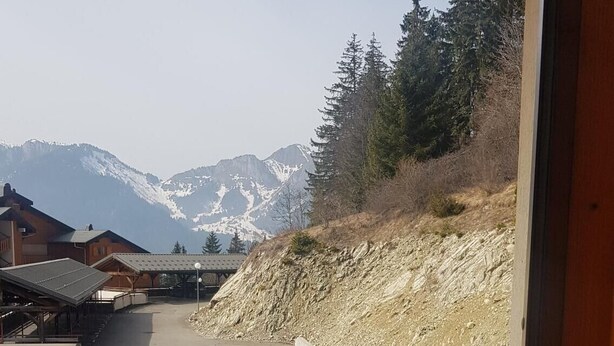 Ein Balkon mit Blick auf Berge und einem Holzzaun.