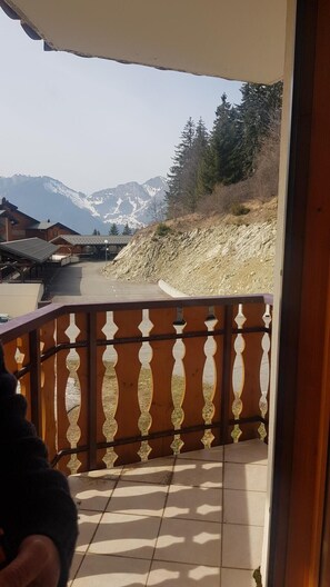 Ein Balkon mit Blick auf Berge und einem Holzzaun.
