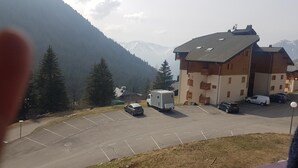 Ein Gebäude mit Parkplatz, einem Wohnmobil und einem Berg im Hintergrund.