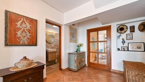 A hallway with a wooden cabinet, a decorative wall piece, a mirror, and a door leading to another room. - Luxurious home in Vucetinec (Vucetinec)