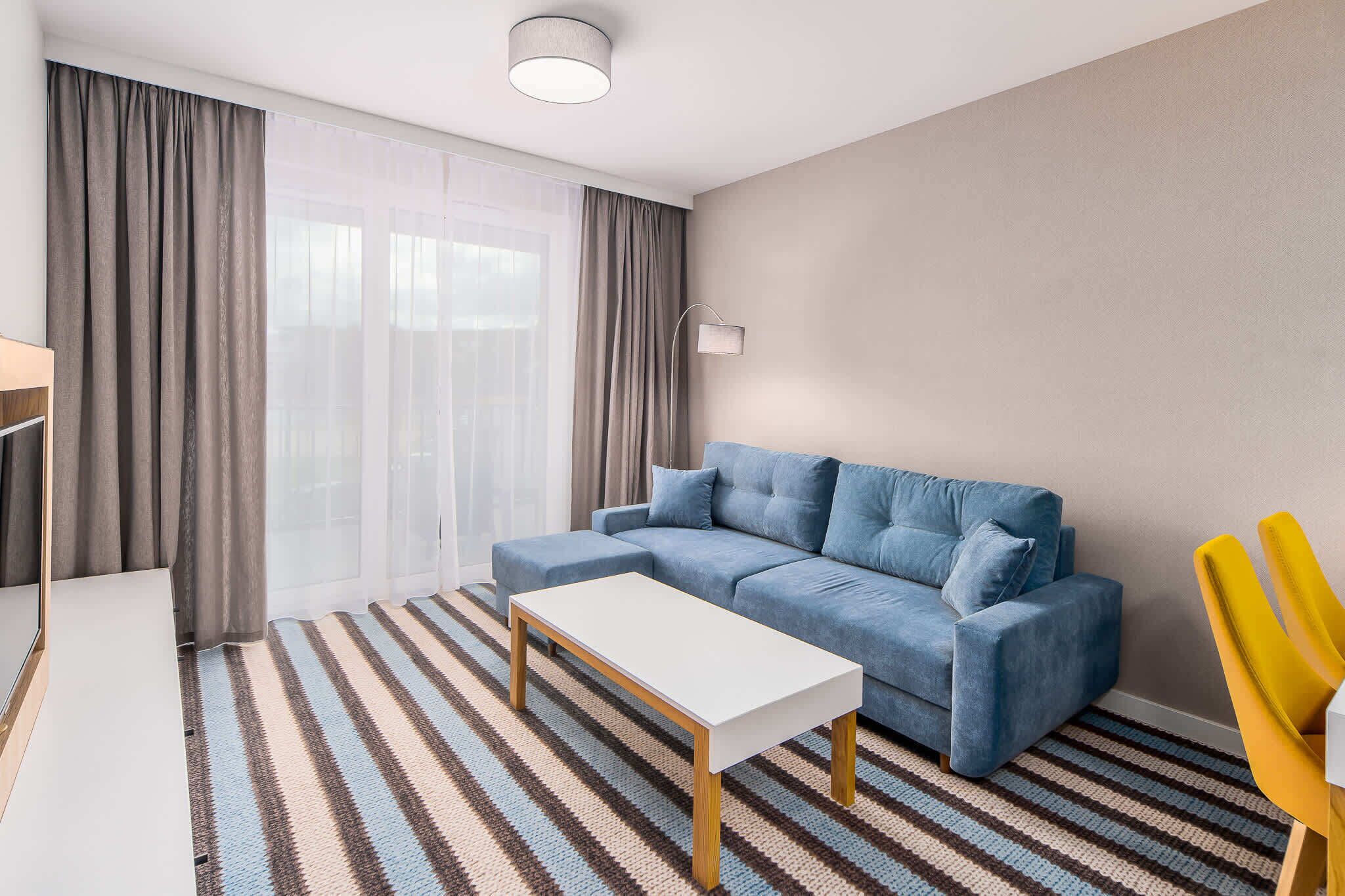 Ein modernes Wohnzimmer mit einer Couch, einem Couchtisch und einem Streifenmuster-Teppich.