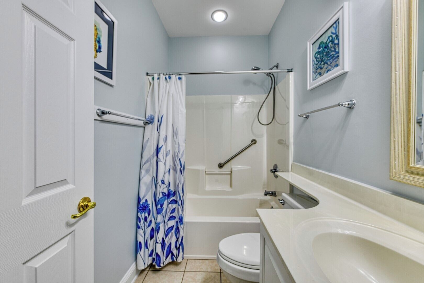 A bathroom with a shower, toilet, and sink.