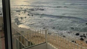 Ein Balkon mit Blick auf Meer und Strand.
