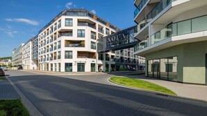 A modern hotel with a prominent sign, multiple floors, and a well-maintained outdoor area.