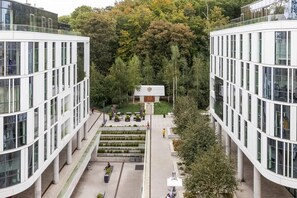 A modern building with a central courtyard, surrounded by trees.