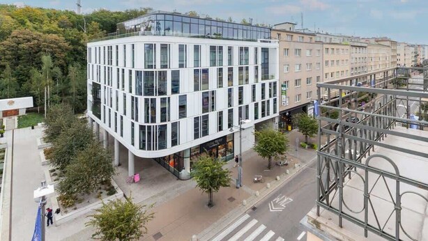 A modern building with a glass facade and a curved corner design.