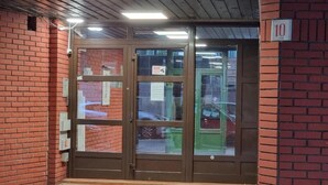 A brick building with a glass door entrance, a number '10' sign, and a security camera. - Big Downtown 2 Bedroom Apartment across National Theater  (Beograd)