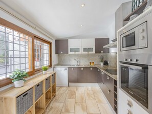 A modern kitchen with a dishwasher, double sink, and built-in oven. - Villa Las Comas de Dalt · 4 bedrooms (Alcúdia)