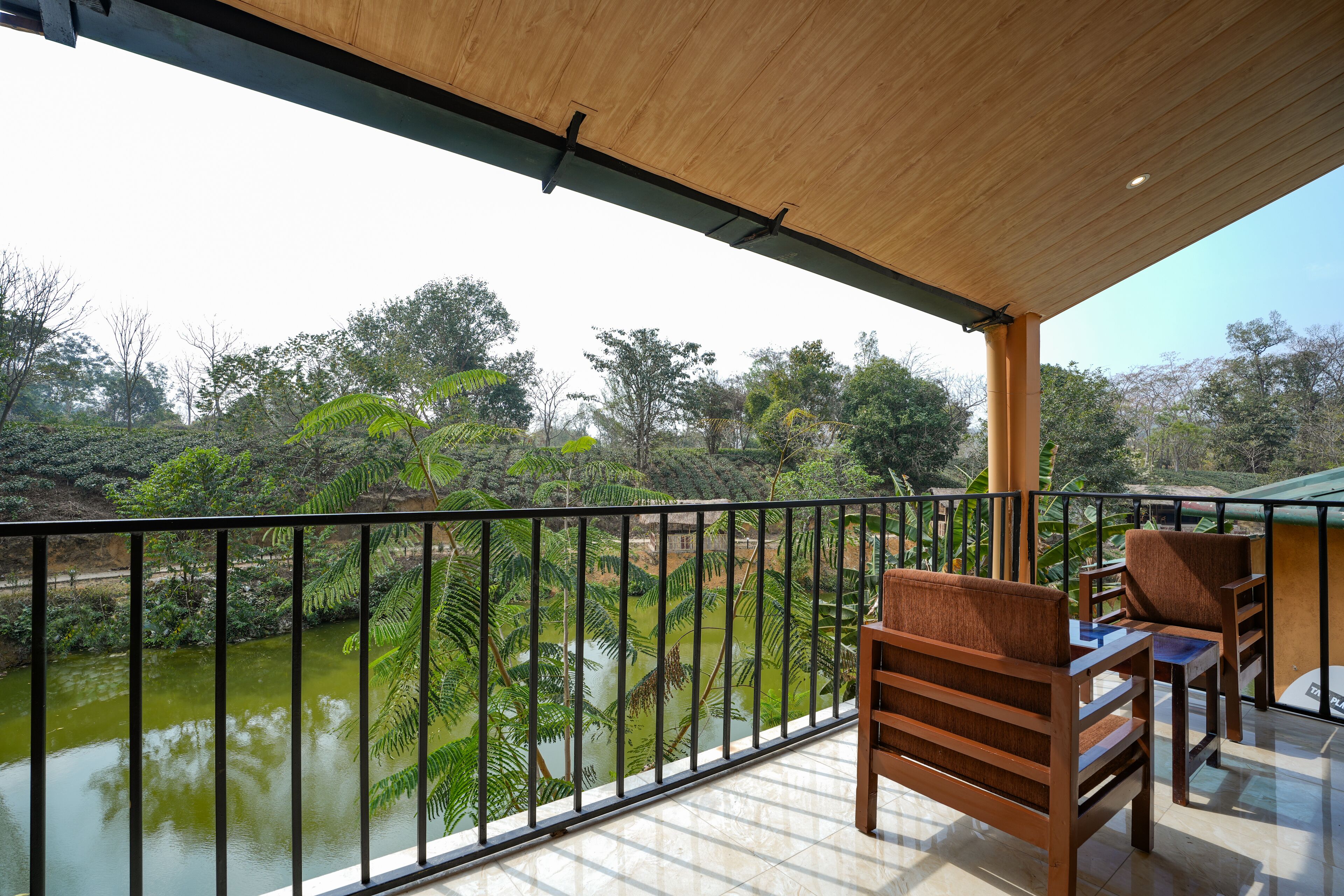 A balcony with a view of a river and surrounding greenery.