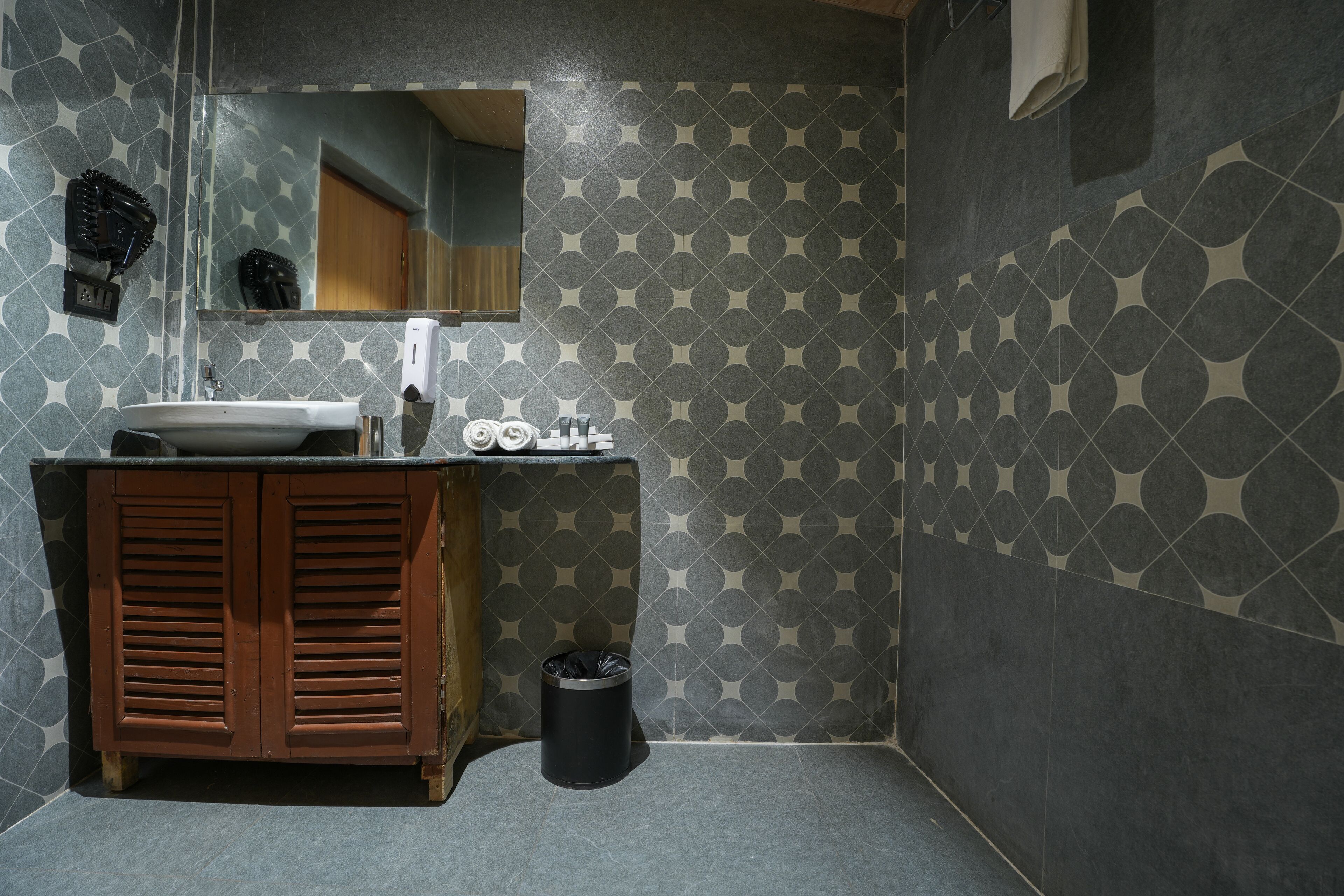 Een badkamer met een wastafel, spiegel en houten kast.
