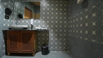 Een badkamer met een wastafel, spiegel en houten kast.