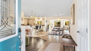 A spacious kitchen with a dining area, a pool, and a living room with a large window. - Dez-Art Retreat - Eclectic Getaway near JTNP (Yucca Valley)
