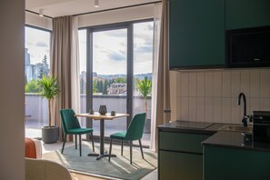 A modern kitchen with a dining area, large windows, and a view of the city.