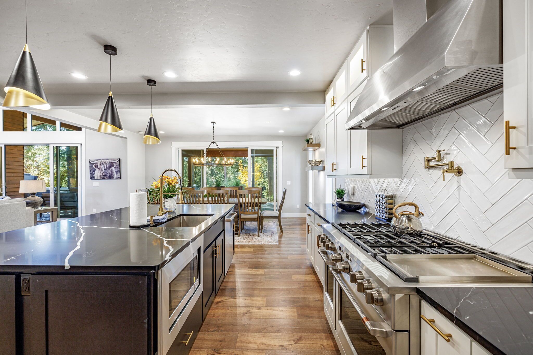 A modern kitchen with a central island, stainless steel appliances, and pendant lighting.