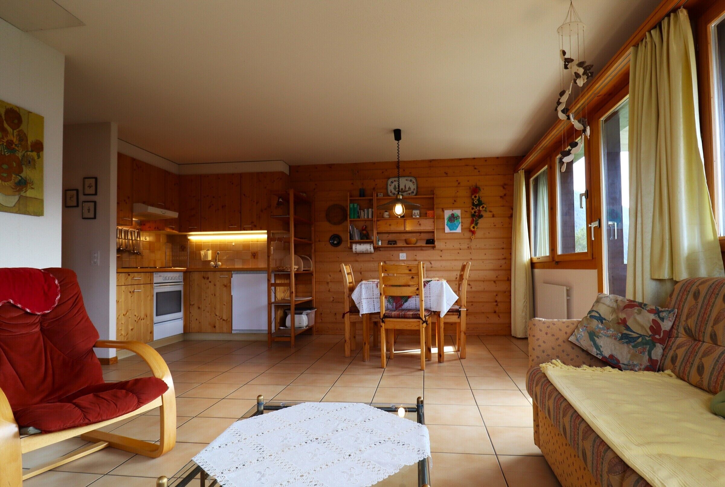 L’intérieur d’un chalet chaleureux, avec un coin repas, des murs en bois et un canapé.