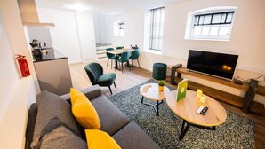 Un salon moderne comprenant un canapé, une table basse, un téléviseur et un coin repas.