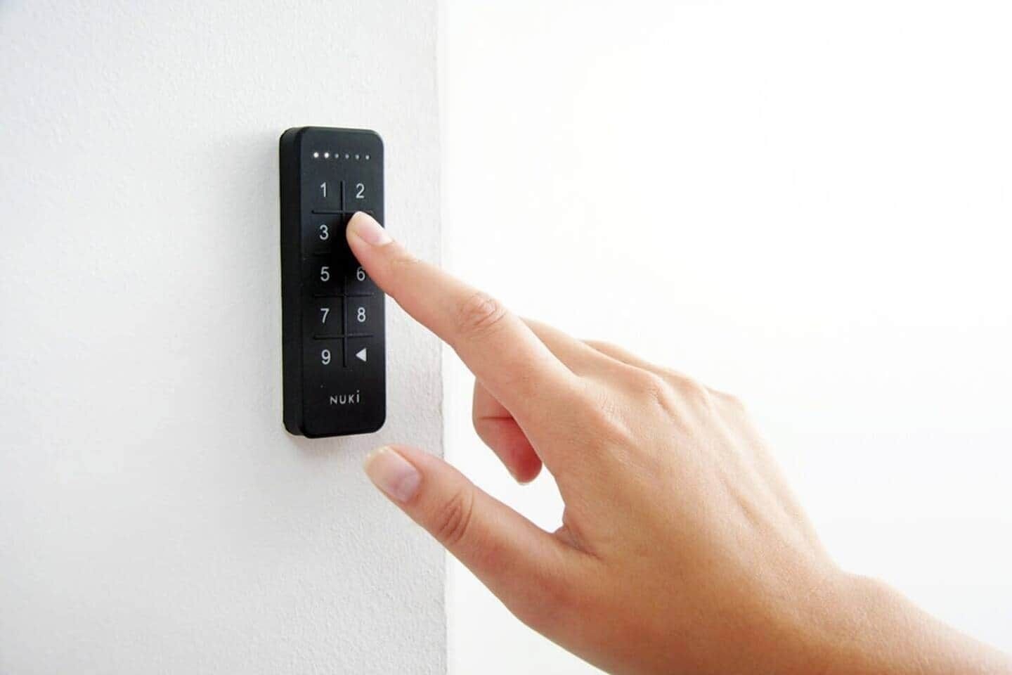 Eine Hand drückt eine Tastatur an einem Türschloss.