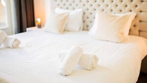 A neatly made bed with white linens and pillows, a tufted headboard, and a bedside lamp. - Divine 50m2 Apartment (WE-39-D) (Tiel)