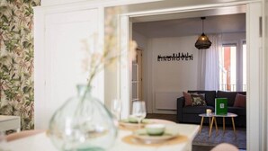 Una sala de estar moderna con un sofá, una mesa con un florero y un cartel que dice 'EINDHOVEN'.