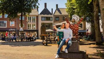 A couple taking a selfie in a public square with buildings in the background.