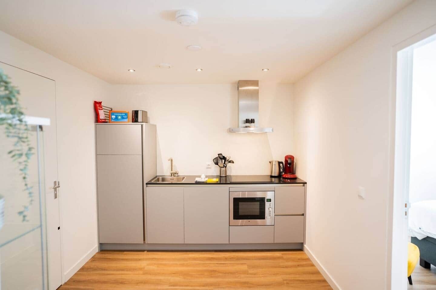 Une cuisine compacte dotée d’un four encastré, d’un évier et d’un petit plan de travail.