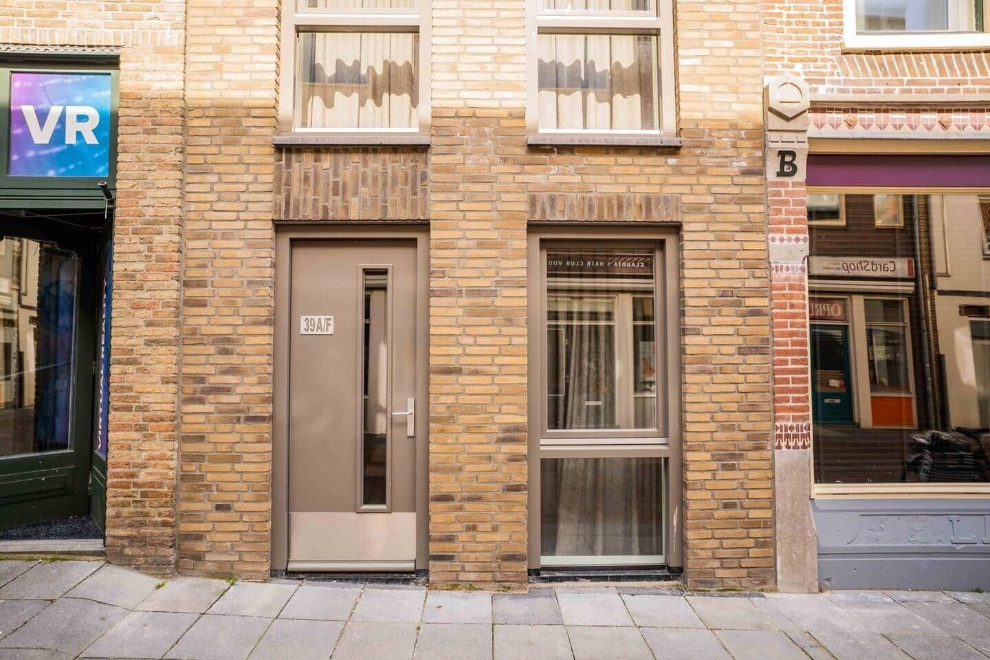 A building with a brick facade, a door labeled '39A/F', and a window with a curtain.