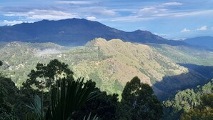 A mountainous landscape with a valley and scattered trees. - Ella Golden view guest (Ella)
