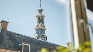 A view of a building with a clock tower through a window.