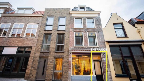 A row of multi-story buildings with a prominent entrance marked 'ENTRANCE' on the facade. - Great 95m2 Two-Bedroom Apartment (WE-39) (Tiel)