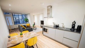 A modern kitchen with a dining area, a sofa, and a coffee machine. - Great 95m2 Two-Bedroom Apartment (WE-39) (Tiel)