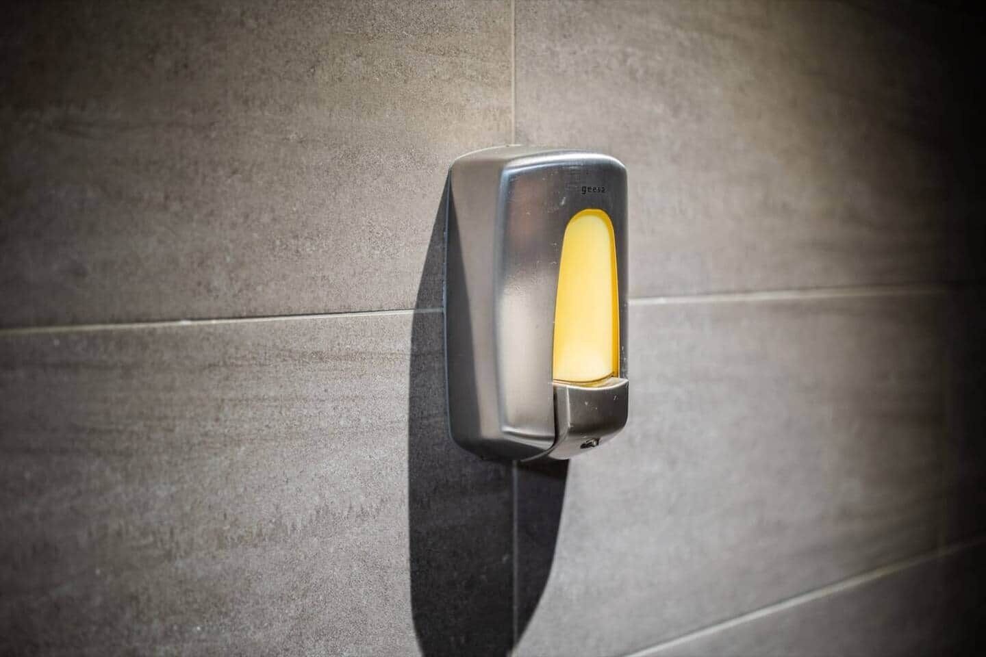 Eine Wandleuchte mit metallischer Oberfläche und gelbem Licht.