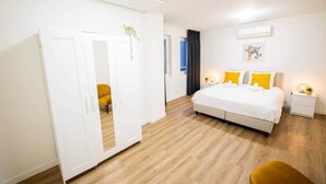 A bedroom with a bed, bedside tables, a wardrobe, and a chair. - Great 95m2 Two-Bedroom Apartment (WE-39) (Tiel)