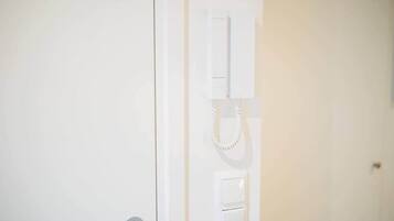 A white door with a telephone mounted on the wall.