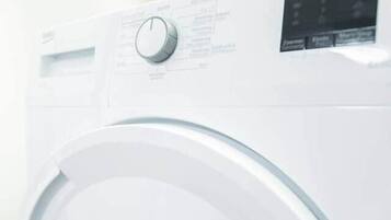 A front view of a white washing machine with a control panel and a digital display.