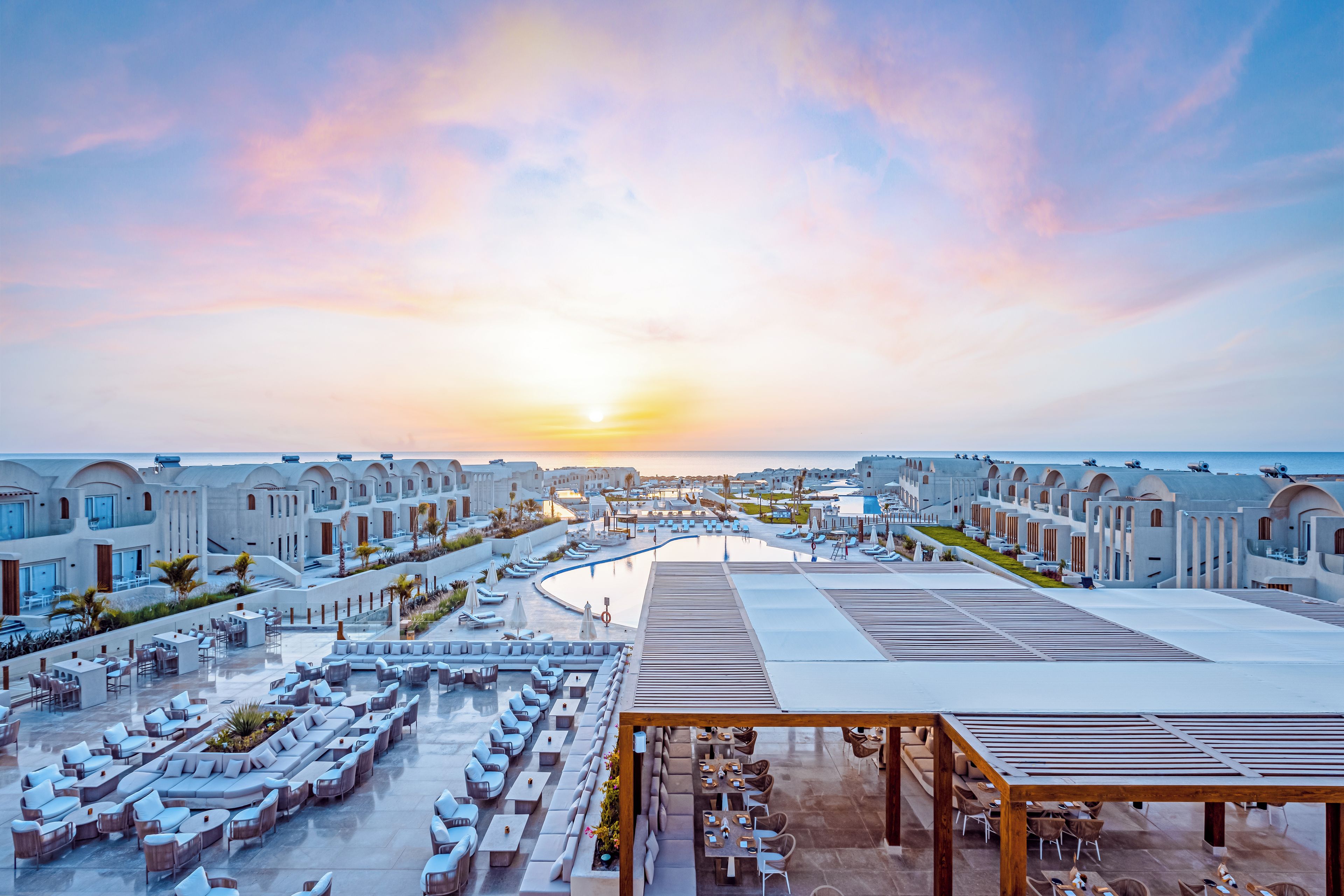 Een resort met meerdere gebouwen, een zwembad en terrasjes.