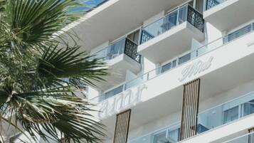Un hotel moderno con varios balcones y una vista despejada del cielo.