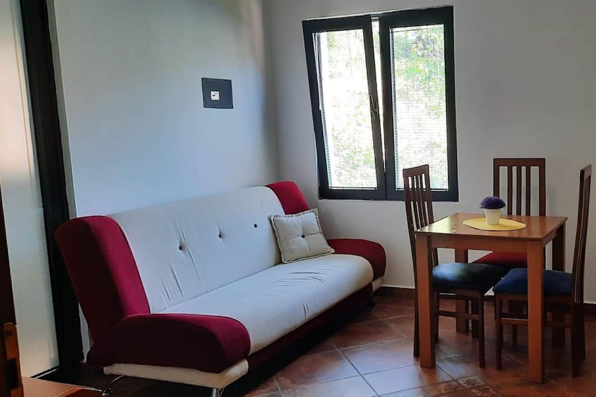 A compact living space with a sofa, a small table, and a chair.