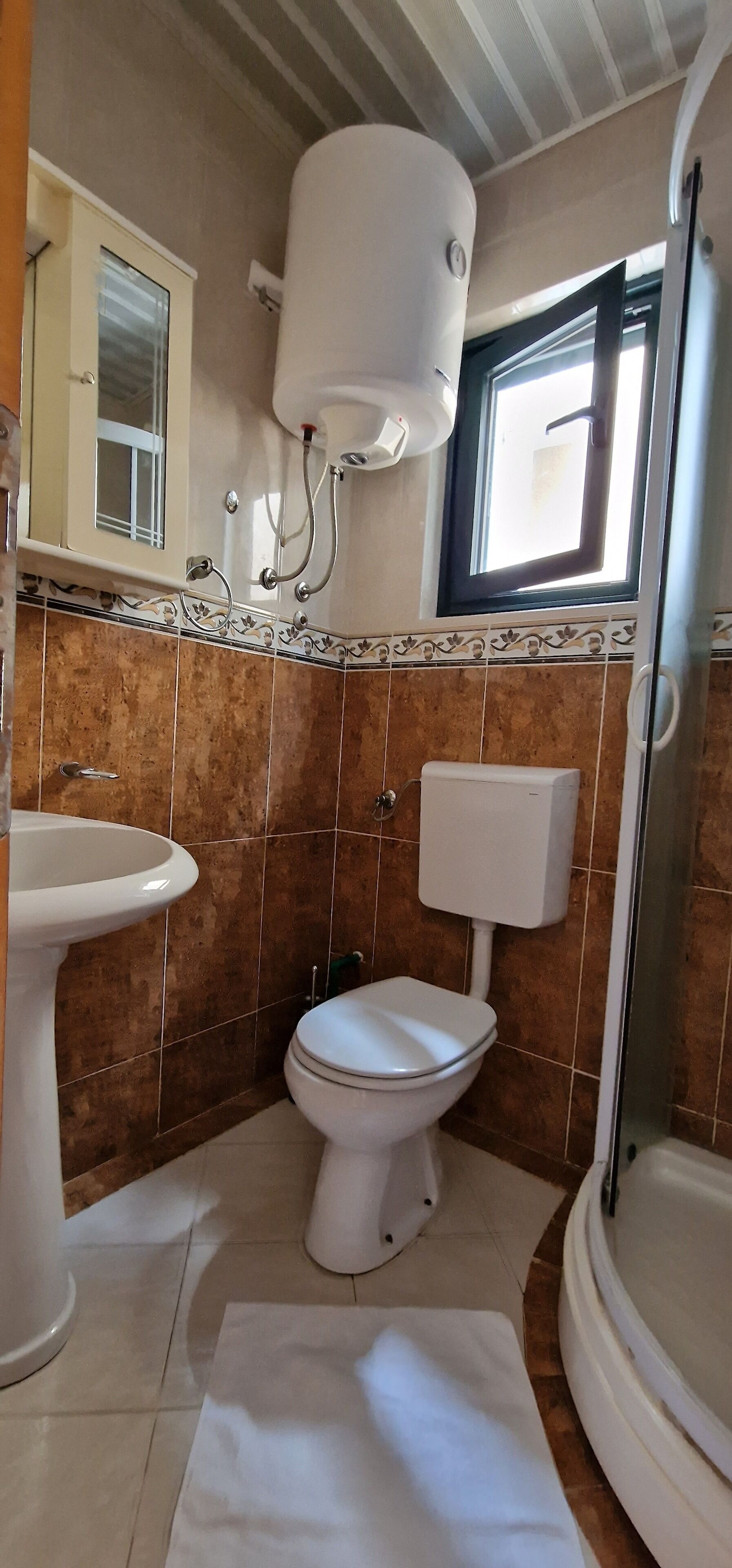 A bathroom with a toilet, sink, and shower.