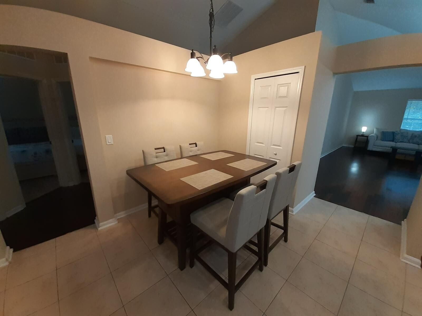 A dining area with a rectangular table, four chairs, and a ceiling light fixture.