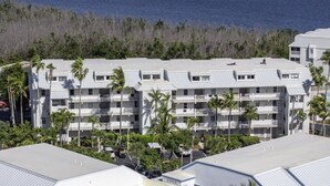 Un hôtel à plusieurs étages doté de balcons, d’un parking et offrant une vue sur l’océan.