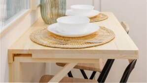 A dining table with a vase of dried plants, two white plates, and a woven placemat. - Designer Apartment - 5 min to Center (Vienna)